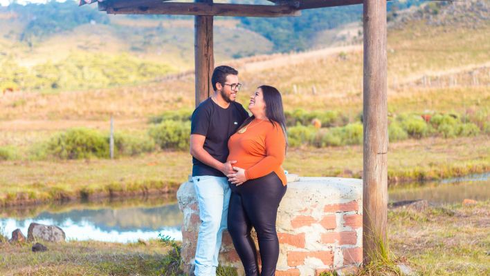 Photo of a Couple Posing by a Well in a Rural Landscape