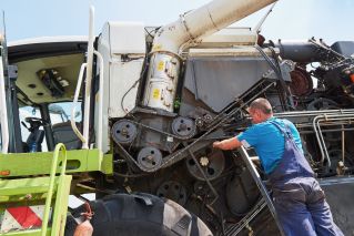 Yellow Backhoe Putting Soil on the Truck